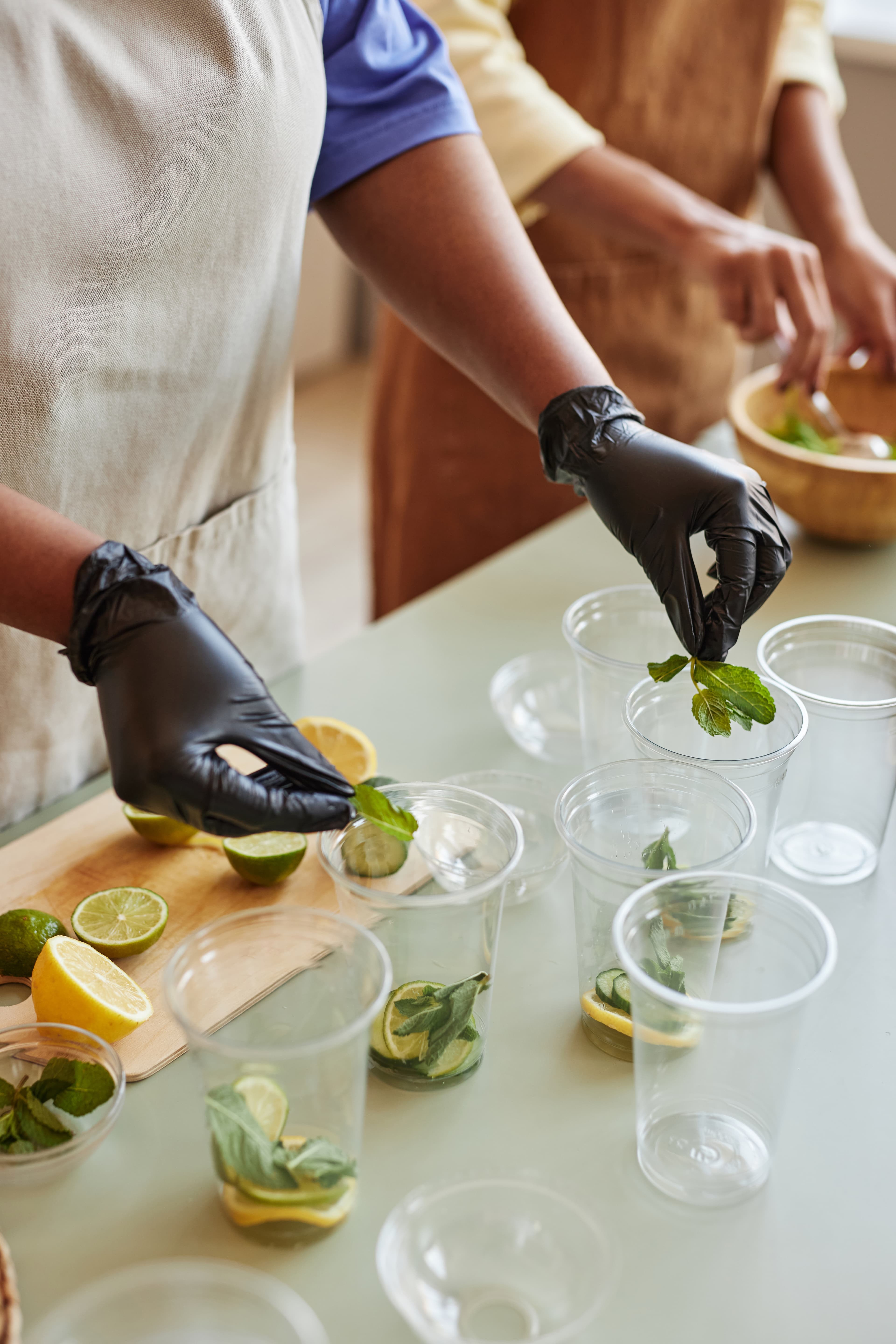 Craft cocktail being prepared with mint leaves