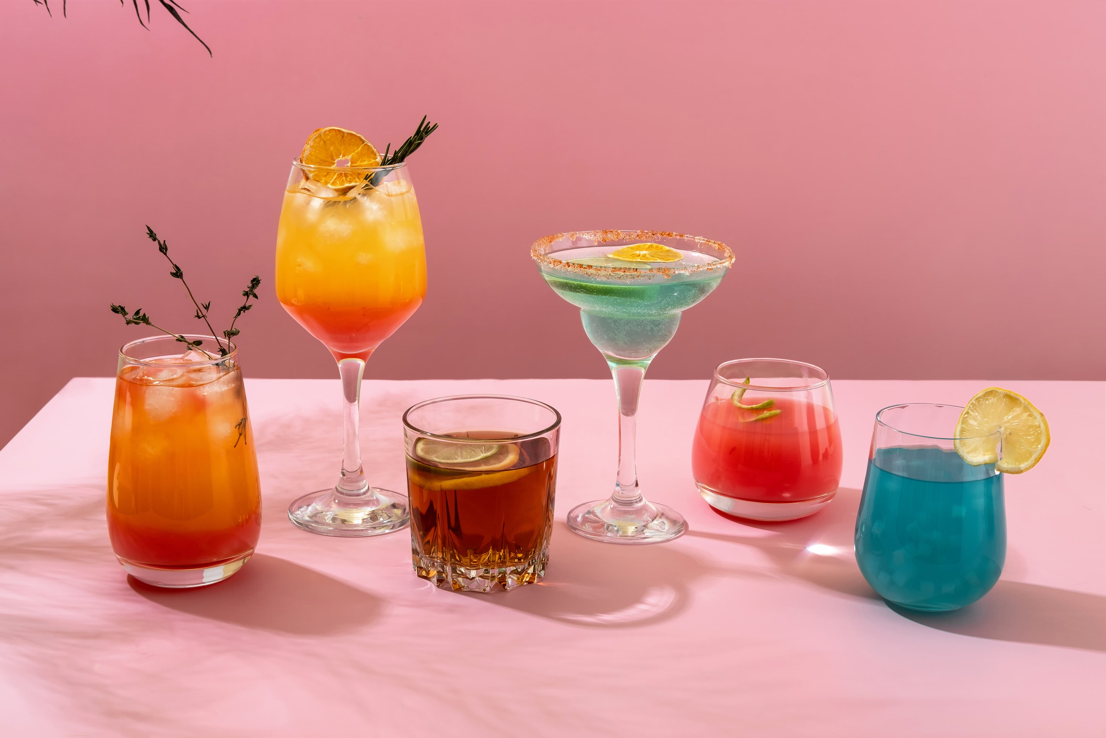 Colorful summer cocktails arranged on pink background